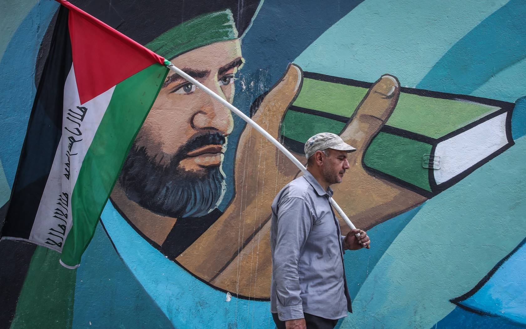 An Iranian man holds a Palestinian flag at an anti-Israel protest.